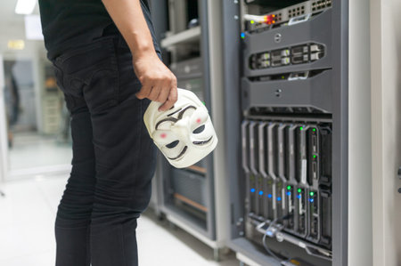 Masked Hacker in Computer Server room Concept .