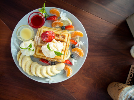 waffle with ice cream and fruits on wood table, top viewの写真素材
