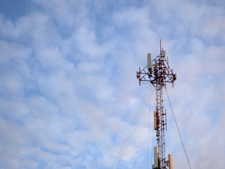 Telecommunication tower with blue sky and white clouds, technology backgroundの写真素材