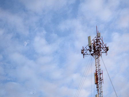 Telecommunication tower with blue sky and white clouds, technology backgroundの写真素材