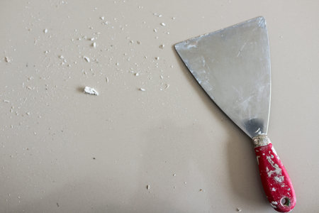 Cans of paint and trowel on a white background.