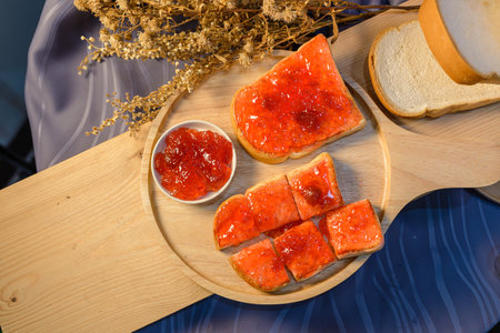 Slices of bread with strawberry jam on a wooden board. .の写真素材