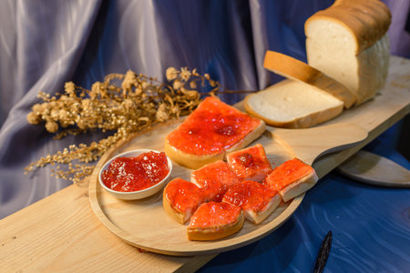 Slices of bread with strawberry jam on a wooden board. .の写真素材