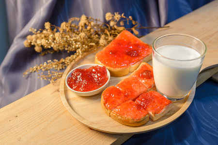 Slices of bread with strawberry jam on a wooden board. .の写真素材