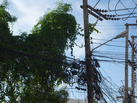 An electrical pole that shows the disorder in the arrangement of the cables.の写真素材