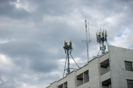 Telecommunication tower with blue sky and white clouds, technology background.