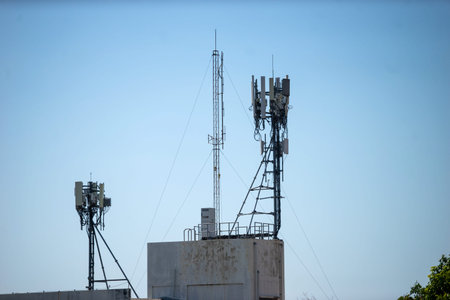 Telecommunication tower with blue sky and white clouds, technology background.
