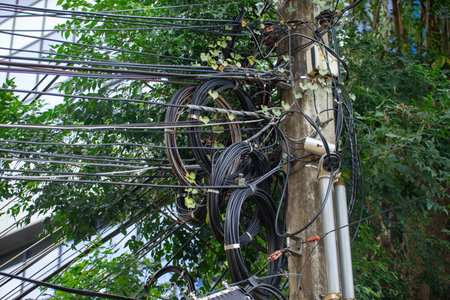 An electrical pole that shows the disorder in the arrangement of the cables.の写真素材