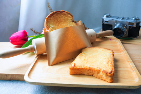 Toast bread with butter and honey on wooden plateの写真素材