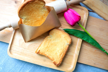 Toast bread with butter and honey on wooden plateの写真素材