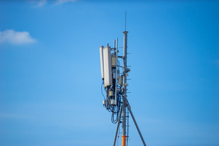 Telecommunication tower with blue sky and white clouds, technology background.の写真素材