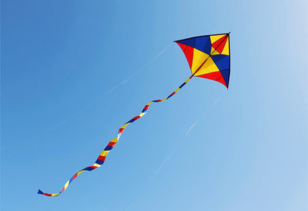 A vibrant red kite soars high in a clear blue sky its long tail streaming behind it.の素材