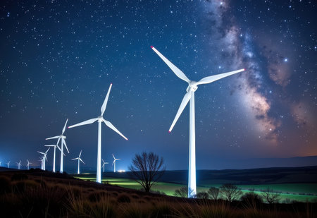 Wind turbines silhouetted against a breathtaking night sky filled with stars  symbolizing renewable energy and sustainable power generation.の素材