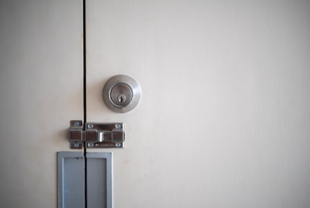 This close-up image showcases a modern door lock and bolt mechanism set against a light background, emphasizing security and functionality in architecture.の写真素材