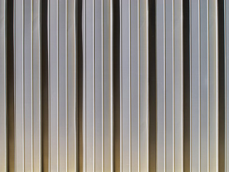 Close-up view of a vertical metal surface showcasing glossy finishes and distinct lines. This texture pattern highlights modern aesthetics, perfect for various design projects.の写真素材