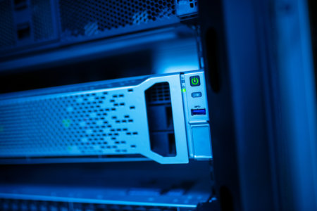 A close-up view of a server rack illuminated by blue lighting, showcasing advanced technology in data storage and network systems. Ideal for tech-related projects.の写真素材