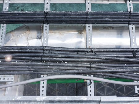 A detailed view of multiple cables and wires arranged on a robust framework. This image showcases...