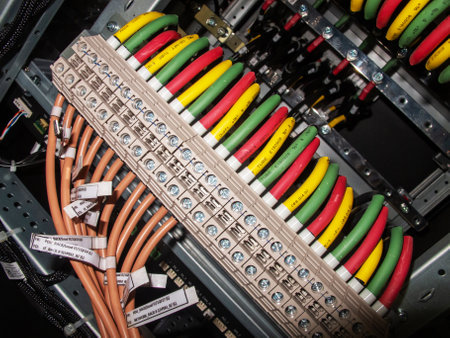 Detailed close-up of color-coded electrical wiring in a control panel, showcasing organized connections and equipment for optimal performance and safety.の写真素材
