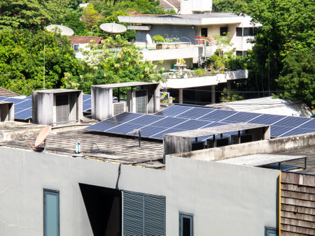 A vibrant image of solar panels installed on rooftops in an urban landscape. The clear, sunny sky highlights renewable energy's role in modern architecture.の写真素材