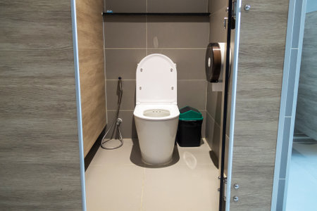 This image showcases a clean modern toilet in a stylish bathroom setting. The design features wood accents and minimalist decor, emphasizing hygiene and comfort.の写真素材