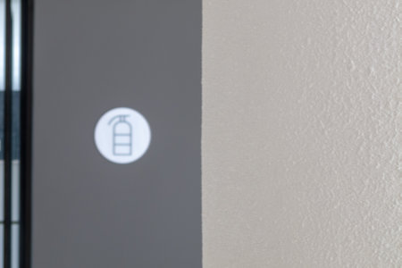 A close-up of a fire safety sign displayed on a wall in a contemporary indoor space. The design emphasizes safety through clear communication and minimalistic aesthetics.の写真素材