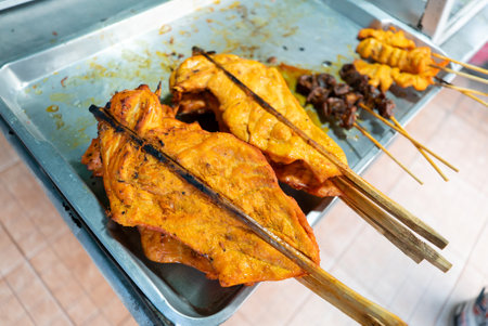 A tray filled with flavorful grilled chicken and skewered meat, perfect for street food fans. The vibrant colors and spices invite those seeking delicious eats.の写真素材