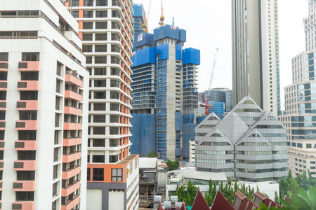 A construction site stands tall amidst modern buildings, showcasing urban development. The image captures the dynamic skyline, emphasizing growth and infrastructure.の写真素材