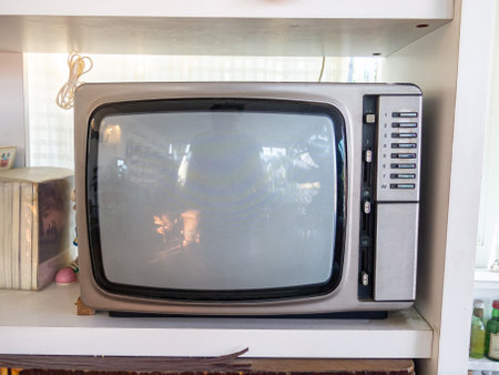 A vintage television set displayed on a shelf, surrounded by minimalist decor. The retro gadget evokes nostalgia, showcasing classic design from the 20th century.の写真素材