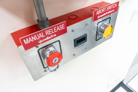Close-up view of an industrial control panel featuring a manual release and an abort switch,...