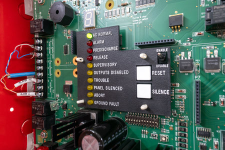 Detailed view of a control panel featuring various indicator lights and switches set on a circuit board, showcasing essential components for system monitoring and safety.の写真素材
