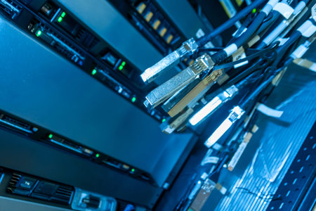 Detailed view of modern data center equipment featuring server racks, network cables, and...