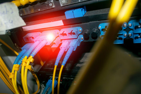 Close-up view of fiber optic cables connected to networking equipment, showcasing vibrant colors and...