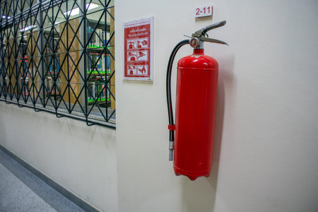 A bright red fire extinguisher mounted on a wall indoors, serving as a critical safety tool....