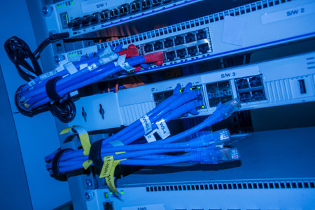 This close-up photo showcases network cables and switches in a data center rack, illustrating the...
