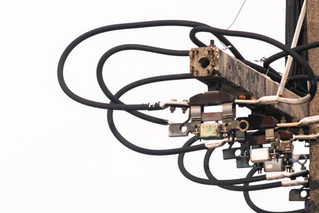 Detailed view of an electrical installation showcasing wires and connectors against a gray sky,...