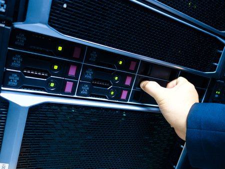 A close-up view of a hand operating a server in a data center, showcasing modern technology and the essential task of network management and maintenance.の写真素材