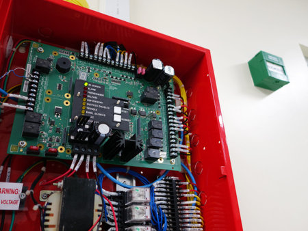 A detailed view of a control system circuit board housed in a vibrant red enclosure, showcasing...