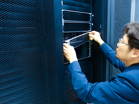 Young asian technician repairing server in datacenter data center.の写真素材