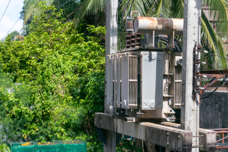An electrical transformer stands prominently among lush greenery, showcasing the intersection of...