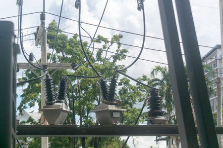 View of electrical power line equipment against a backdrop of cloudy sky, showcasing utility...