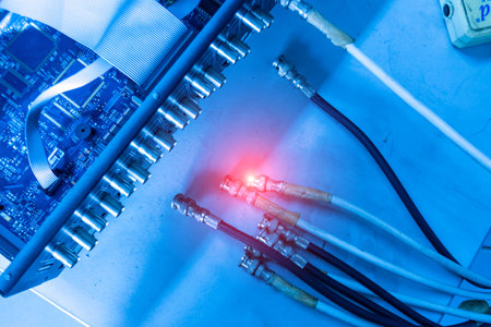 A close-up view of an electronic circuit board showcasing various colorful connections and lights. The image captures a modern technological environment.の写真素材