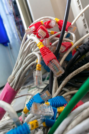 A close-up view of a tangled mess of colorful network cables and connectors. This image showcases the complexity of technology installations.の写真素材
