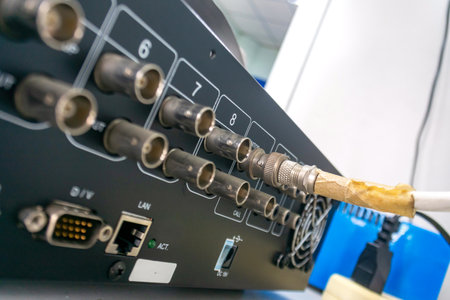 Detailed view of the back panel of electronic equipment capturing connectors and cables in an office setting. Ideal for technology and hardware themes.の写真素材