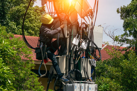 A skilled technician performing maintenance on electrical equipment in an outdoor setting, showcasing a blend of technology and nature, safety gear included.の写真素材