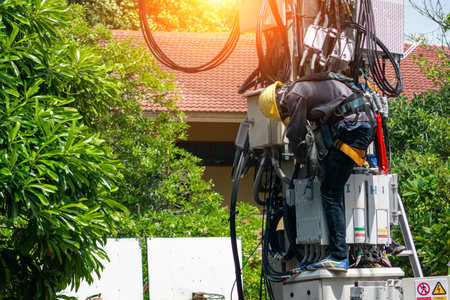 An electric technician works diligently on equipment, ensuring smooth operation. The outdoor scene highlights safety measures and essential tools in action.の写真素材