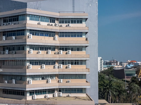A modern building featuring numerous air conditioning units on its exterior, showcasing urban architecture and effective climate control solutions in an urban environment.の写真素材