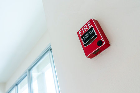 Red fire alarm box mounted on a wall provides important safety measures. Essential for emergency situations, it ensures quick action and alerts occupants.の写真素材