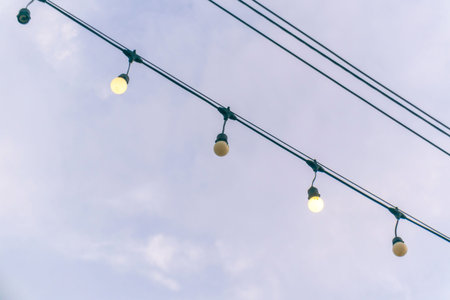 Soft glowing lights hang against a gentle sky, creating a warm and inviting atmosphere ideal for...