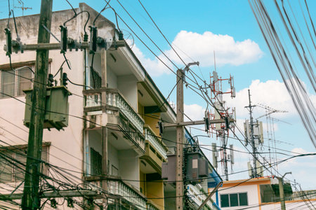 A vibrant urban scene showcasing buildings, power lines, and telecommunications equipment under a...