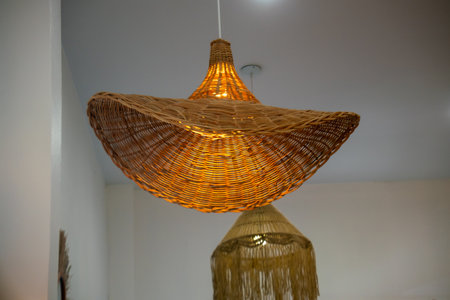 This captivating woven bamboo light fixture adds a warm glow to any space, showcasing unique craftsmanship and modern design elements for an inviting ambience.の写真素材